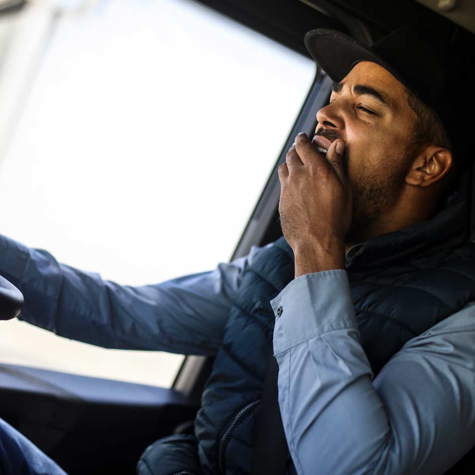 A man yawning whilst driving
